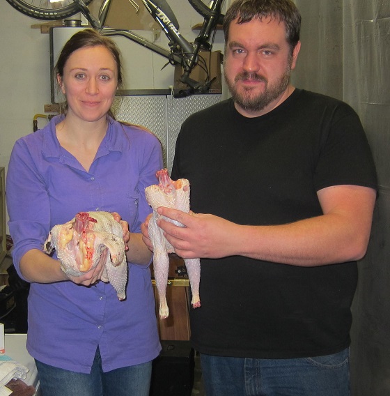 woman and man holding butchered chickens